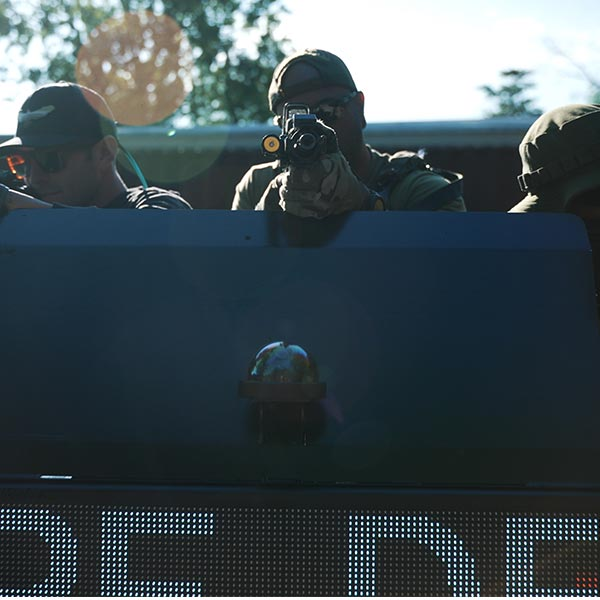 Officers taking cover behind a ballistic deflection system