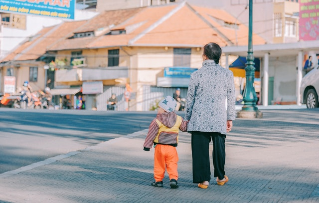 A parent helping a child cross the road