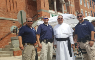 Security officers providing VIP protection to a priest