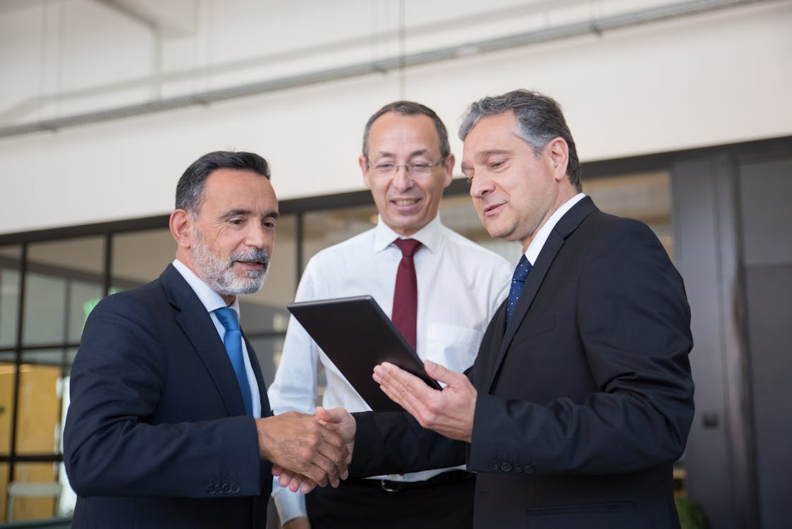 An image of executives looking at a tablet 